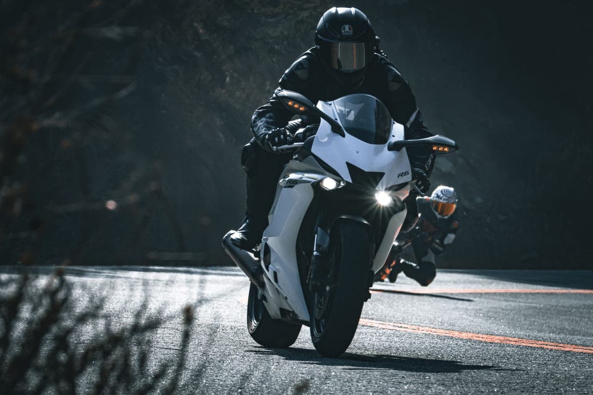 A new rider in full gear standing beside a motorcycle