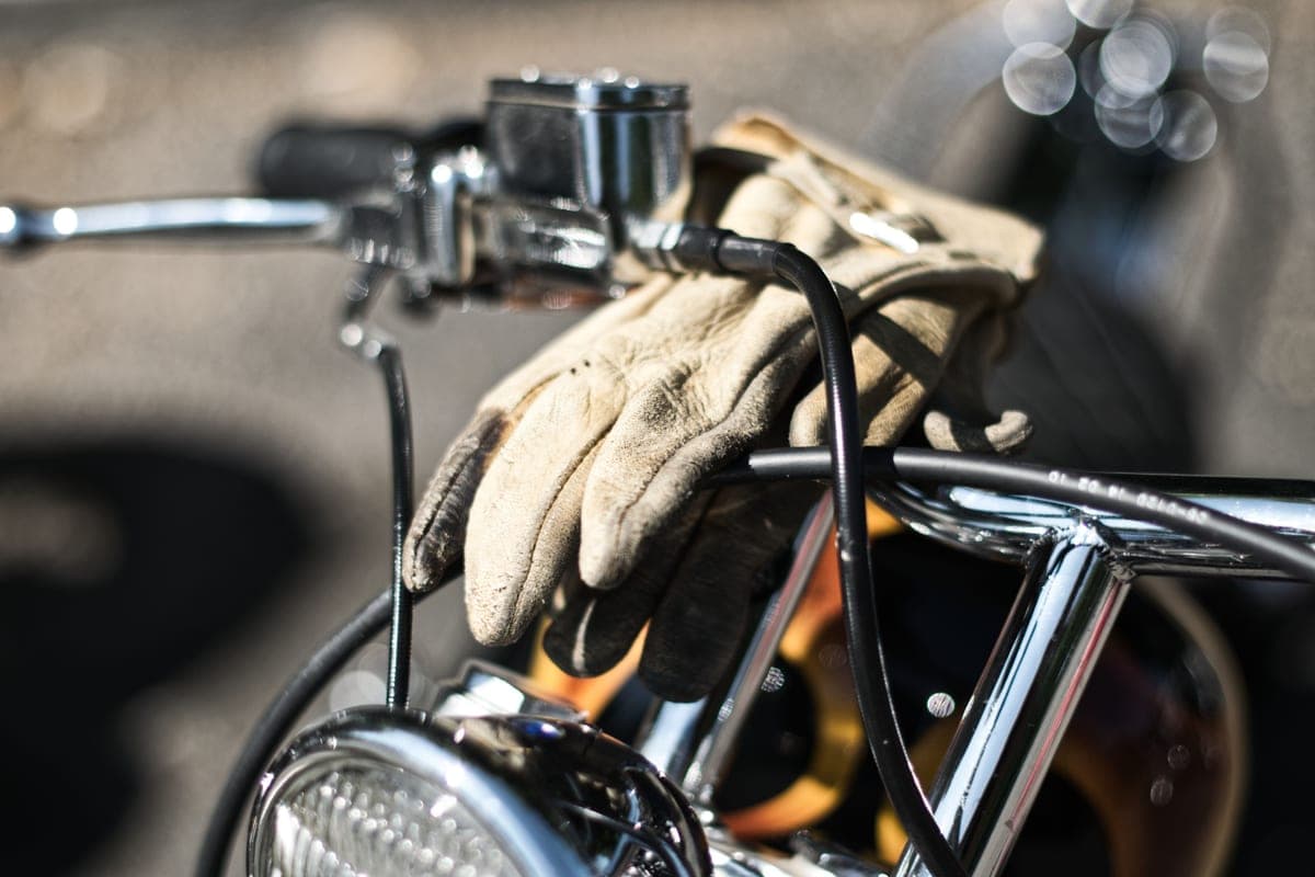 Gloved hands gripping motorcycle handlebars