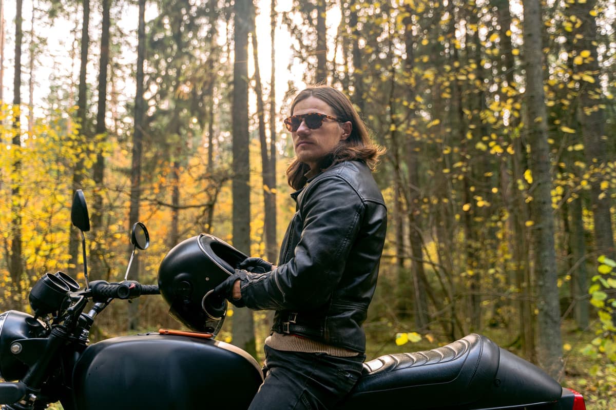 A rider in a protective motorcycle jacket on the road