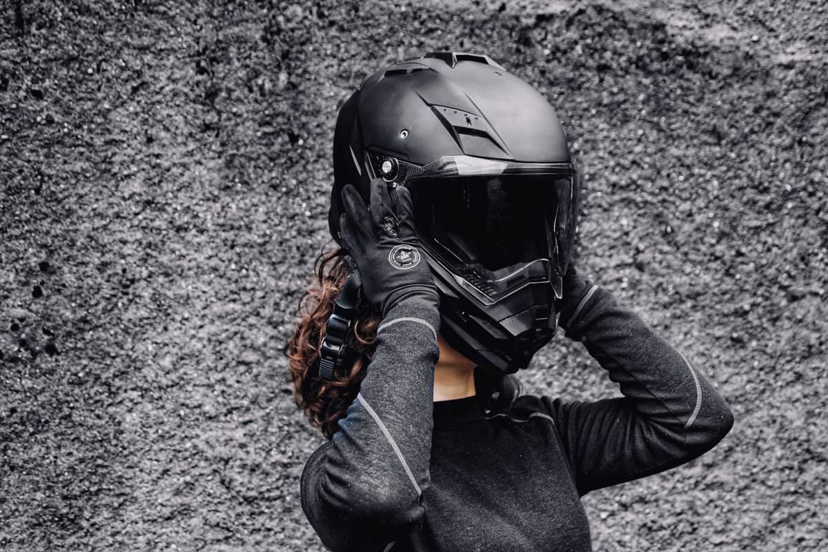 A rider fitting a full-face helmet